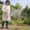 立ったまま長柄の草取り道具を使う日本人女性