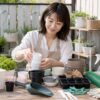 100均でそろえやすい植木鉢や園芸小物を選ぶ日本人女性