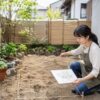 庭の設計図を確認しながらレイアウトを測る日本人女性
