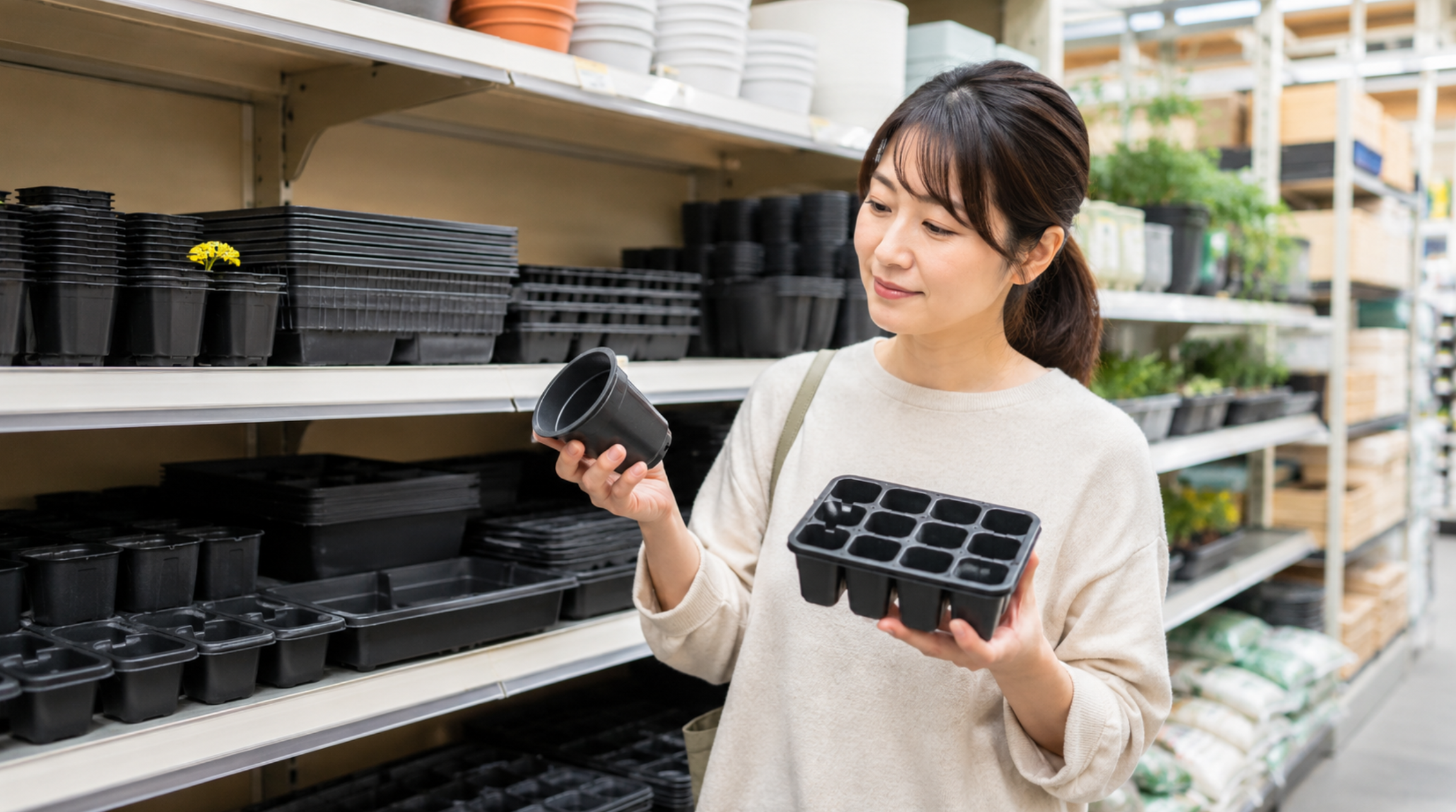 園芸店で育苗ポットと育苗トレーを比較して選ぶ女性